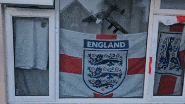 a flag that says england is hanging in a window