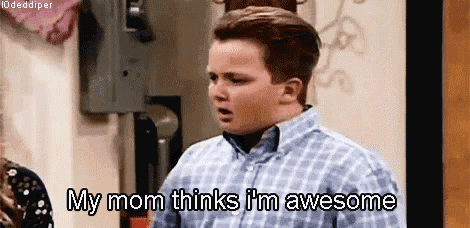 a young boy is standing in front of a wall and says `` my mom thinks i 'm awesome ''