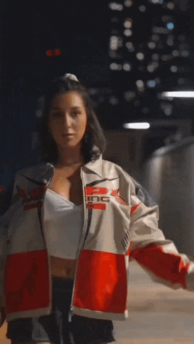 a woman wearing a red white and black jacket that says racing on it