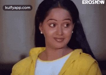 the woman is wearing a yellow jacket and smiling .