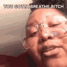 a woman wearing glasses and an oxygen mask is making a funny face and saying you gotta breathe bitch .