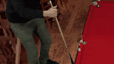 a man is holding a pool cue in front of a pool table with the number 9 on it