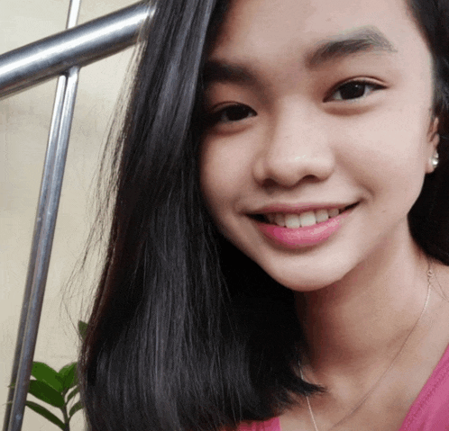 a close up of a girl 's face with a pink shirt on