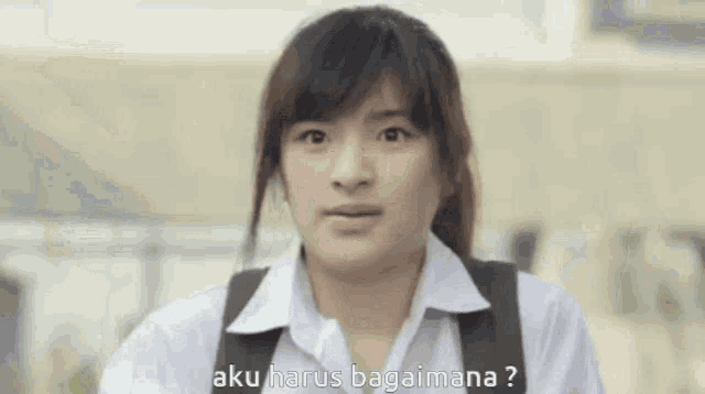 the girl is wearing a white shirt and a black backpack and is asking a question .