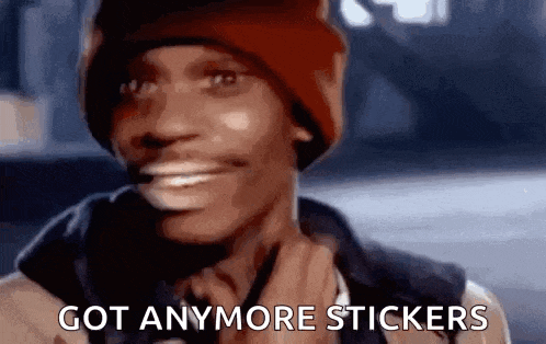 a man wearing a red beanie is smiling and says `` got anymore stickers '' .