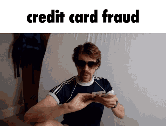 a man wearing sunglasses is holding a credit card in his hand