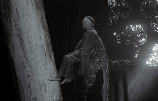 a statue of a woman sitting on a tree trunk in a dark room with balloons hanging from the ceiling