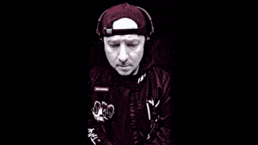 a man wearing headphones and a hat has a patch on his jacket that says ' tmo johnson ' on it