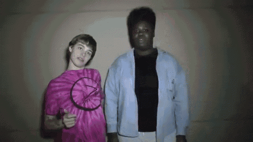 a man and a woman are standing next to each other in a room .