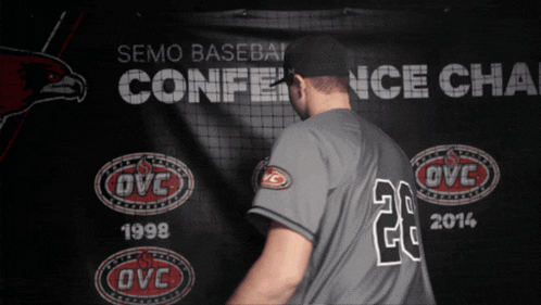 a baseball player in front of a banner that says semo baseball conference