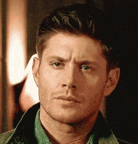a close up of a man 's face wearing a green shirt and a jacket .