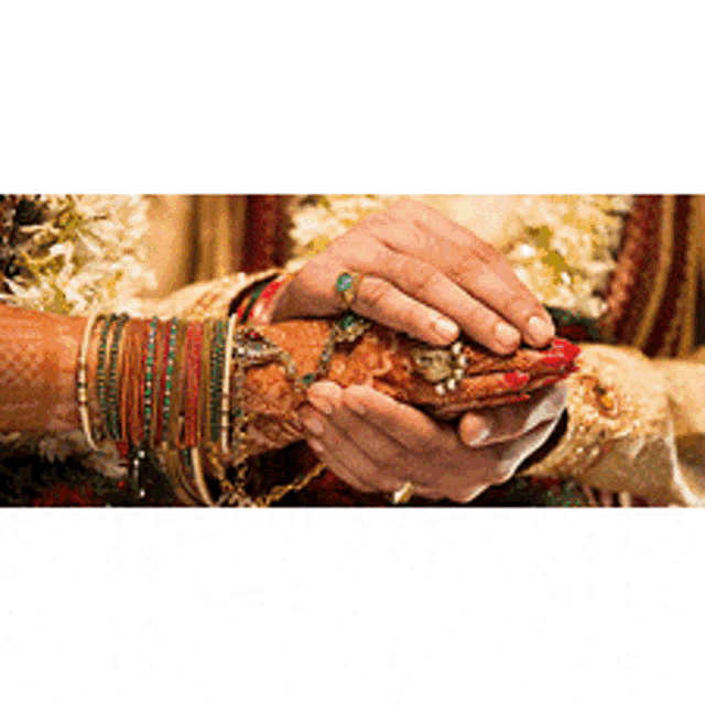 a bride and groom are holding each other 's hands during a wedding ceremony .