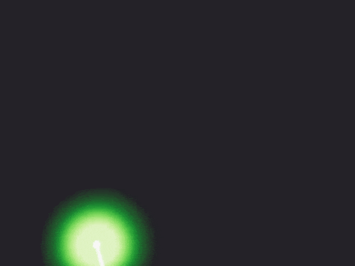 a green light is shining in the dark with a white arrow coming out of it