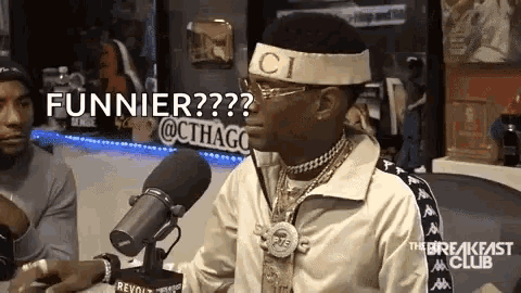 a man is sitting in front of a microphone wearing a headband that says gucci on it .