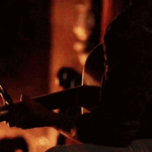 a man and woman are looking at each other in a dark room .