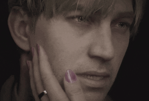 a close up of a man 's face with a woman 's hand touching his face