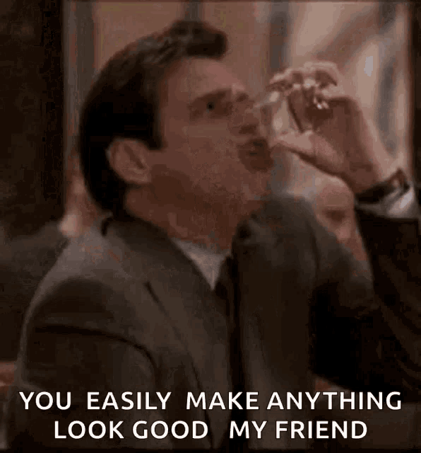 a man in a suit and tie is drinking from a glass and saying " you easily make anything look good my friend "