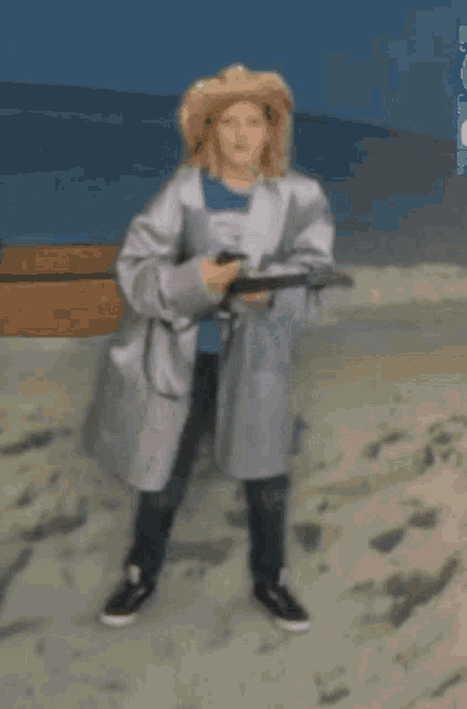 a woman in a white coat walking on a beach