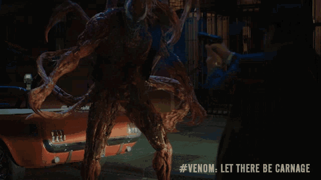 a man holding a gun in front of a monster with #venom let there be carnage on the bottom