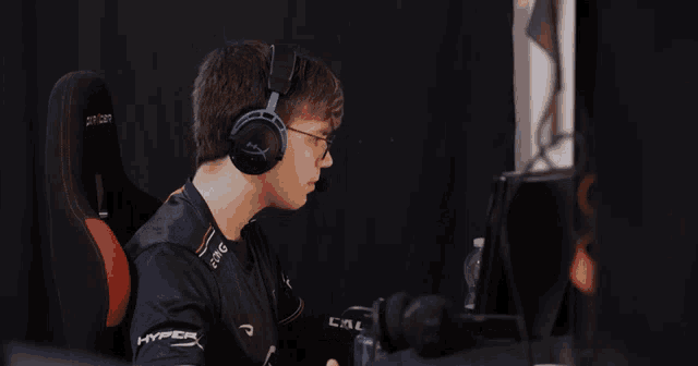 a man wearing headphones and a hyperx shirt