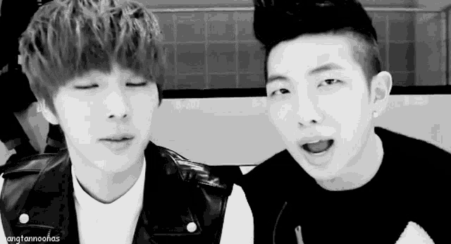two young men are looking at each other and one has his eyes closed