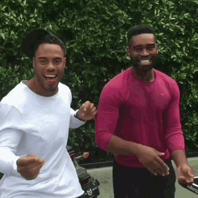 two men standing next to each other with one wearing a pink shirt that says nike