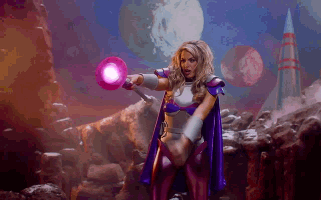 a woman in a purple cape is holding a purple object in her hand