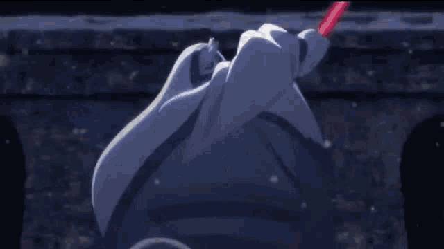 a close up of a person holding a red light saber in their hand .