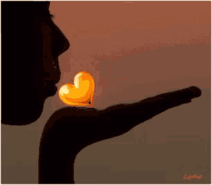 a silhouette of a woman blowing a heart shaped candle