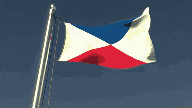 a red white and blue flag is flying on a flag pole