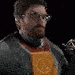 a man with glasses and a beard is drinking from a bottle while holding a bag of chips .
