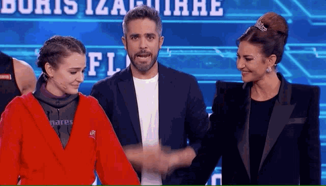a man and two women are shaking hands in front of a sign that says floris iza