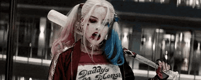 harley quinn from suicide squad is holding a bat and a sword in her hand .