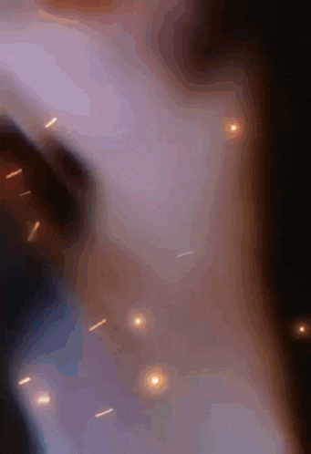 a close up of a person 's face with sparks flying around