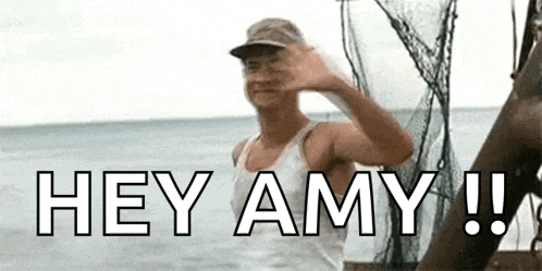 a man is standing on a boat in the ocean waving his hand and says `` hey amy '' .