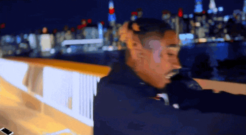 a blurry photo of a man standing on a bridge at night