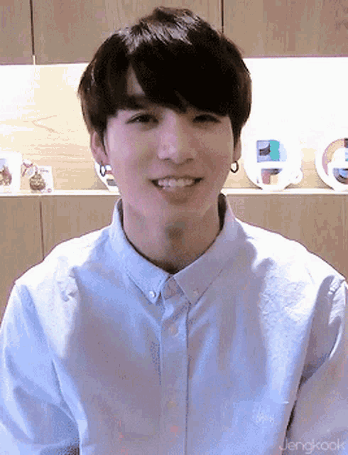 a young man wearing a blue shirt with the name jengkook on the bottom