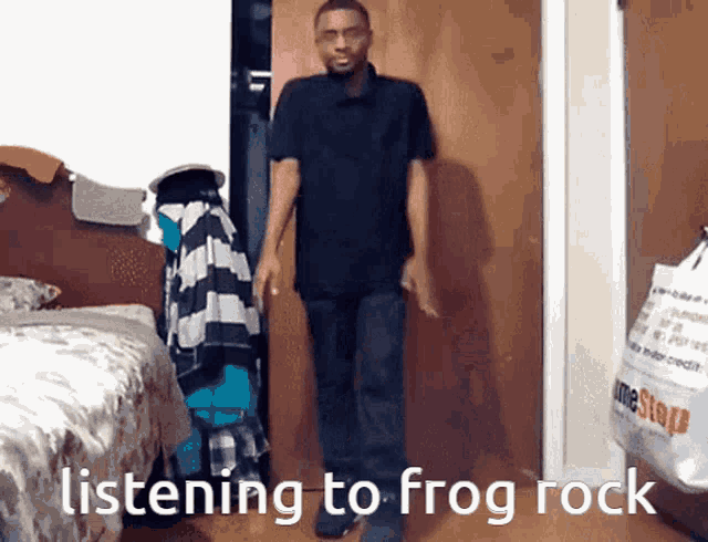 a man is listening to frog rock while standing in a room