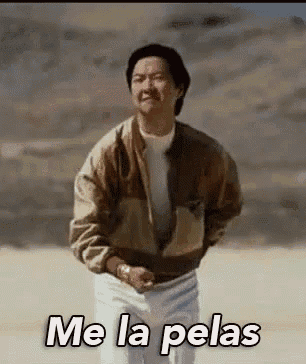 a man is standing in the desert with the words `` me la pelas '' written on his chest .