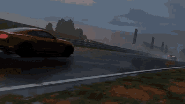 a red car is driving down a wet track