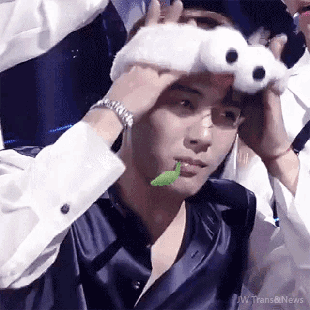 a man is holding a stuffed animal on his head .