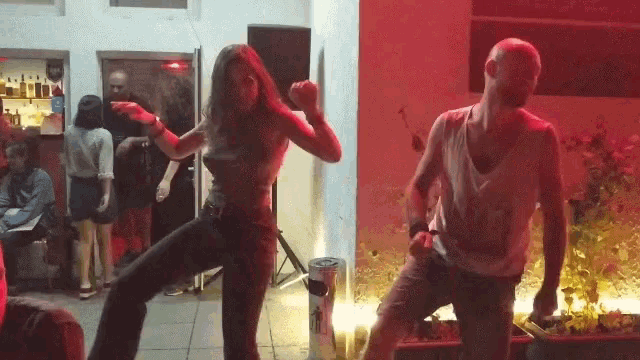 a man and a woman are dancing in a red room