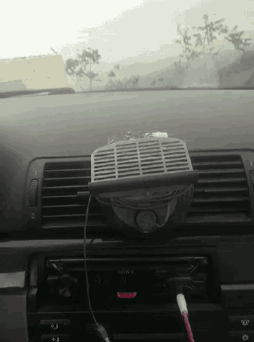 a car dashboard with a sony radio and a fan attached to it