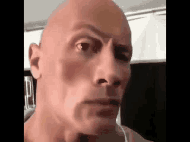 a close up of a bald man 's face with headphones on .