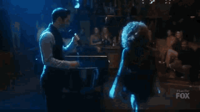 a man and a woman are dancing together in front of a crowd .