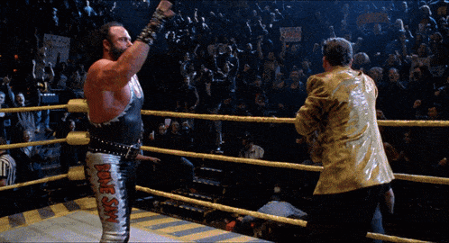 a wrestler in a ring with the word bone on his pants