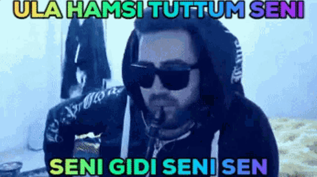 a man wearing sunglasses and a hooded sweatshirt with the words seni gibi seni sen below him