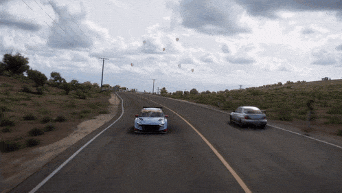 two cars are driving down a road in a video game