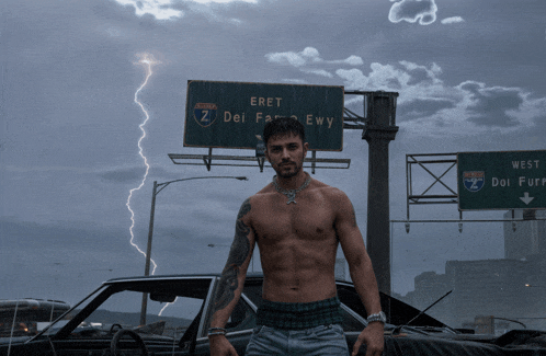 a shirtless man stands in front of a sign for eret