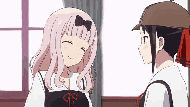 a girl with pink hair is smiling next to another girl wearing a hat